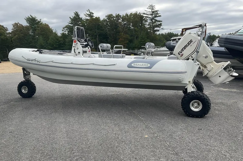 The Image of 2011 Sealegs 7.1 amphibious boat with Evinrude engine on land, showcasing rugged wheels. - 0