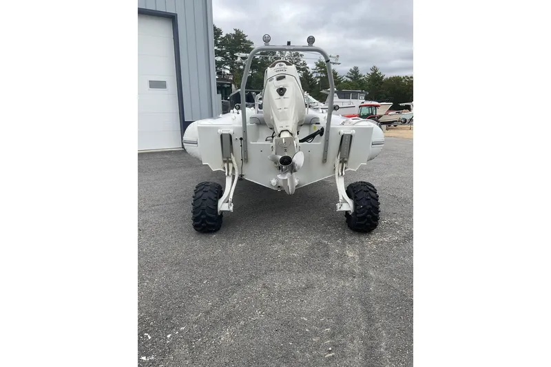 Slide: The Image of 2011 Sealegs 7.1 amphibious boat with wheels, parked on pavement near a building. - 13