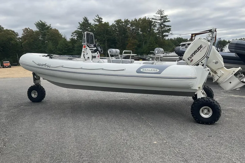 Slide: The Image of 2011 Sealegs 7.1 amphibious boat with Evinrude motor on land, surrounded by trees. - 14