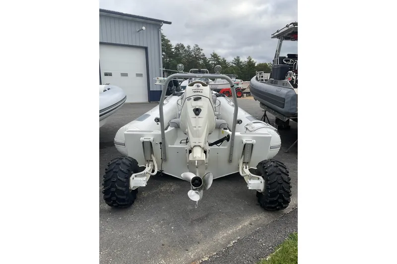 Slide: The Image of 2011 Sealegs 7.1 amphibious boat with wheels, parked outdoors near a garage. - 3