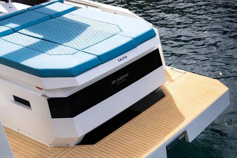 Slide: The Image of 2026 De Antonio Yachts D29 with blue seating and teak deck, docked on water. - 15