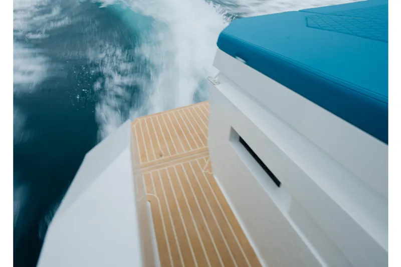 Slide: The Image of 2026 De Antonio Yachts D29 in clear blue waters near rocky cliffs. - 6