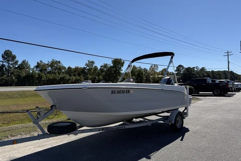 Slide: The Image of 2023 Stingray 172SC boat on trailer, parked outdoors under clear blue sky. - 3