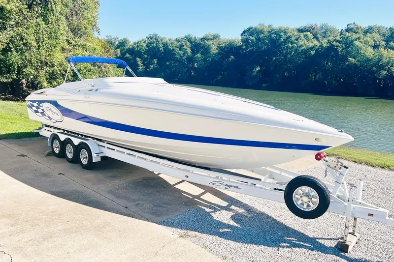 The Image of 1996 Baja .38 Special boat on trailer by a river, featuring sleek design and blue accents. - 0