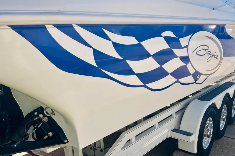 Slide: The Image of 1996 Baja .38 Special boat with blue checkered design on trailer. - 10