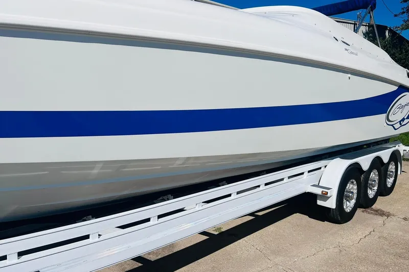 Slide: The Image of 1996 Baja .38 Special boat on trailer with blue stripe and triple-axle wheels. - 17