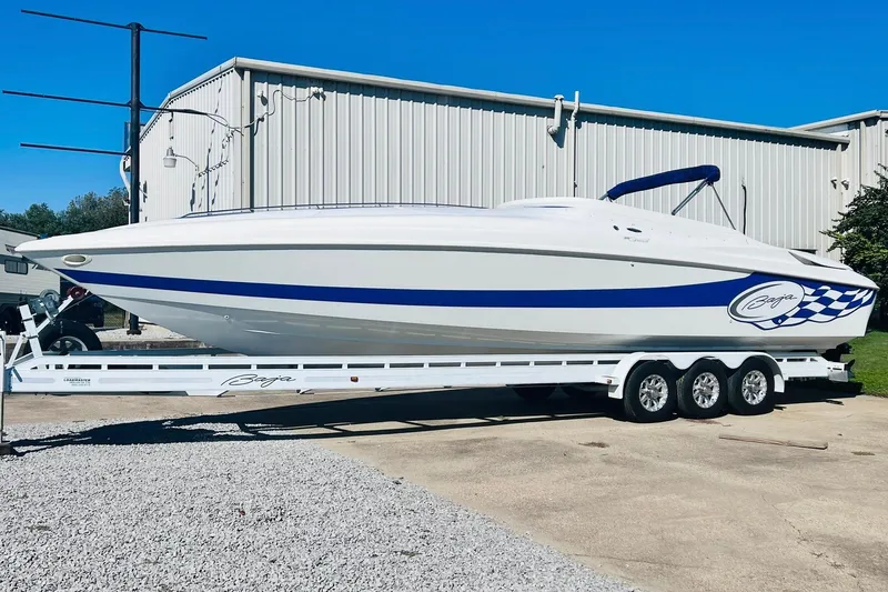 Slide: The Image of 1996 Baja .38 Special boat on trailer, white with blue accents, parked outdoors. - 3