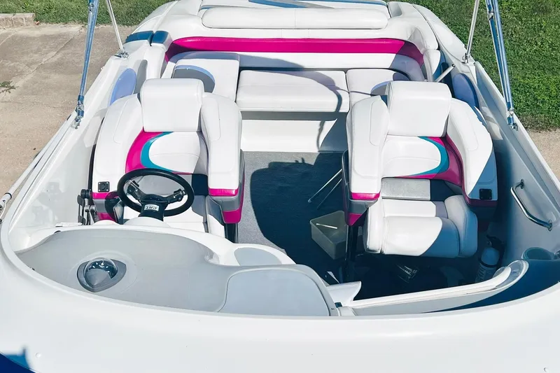 Slide: The Image of 1996 Baja .38 Special boat interior with white and pink seating, steering wheel, and open deck. - 32