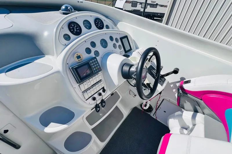 Slide: The Image of 1996 Baja .38 Special boat cockpit with steering wheel, gauges, and vibrant seating. - 34