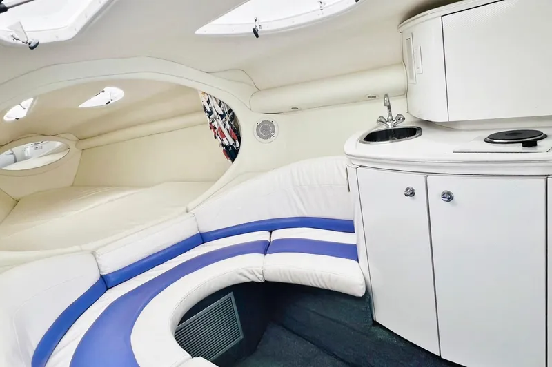 Slide: The Image of Interior of a 1996 Baja .38 Special boat with white and blue seating, kitchenette. - 54