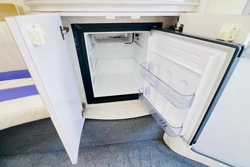 Slide: The Image of 1996 Baja .38 Special interior with open cabinet revealing a compact refrigerator. - 57