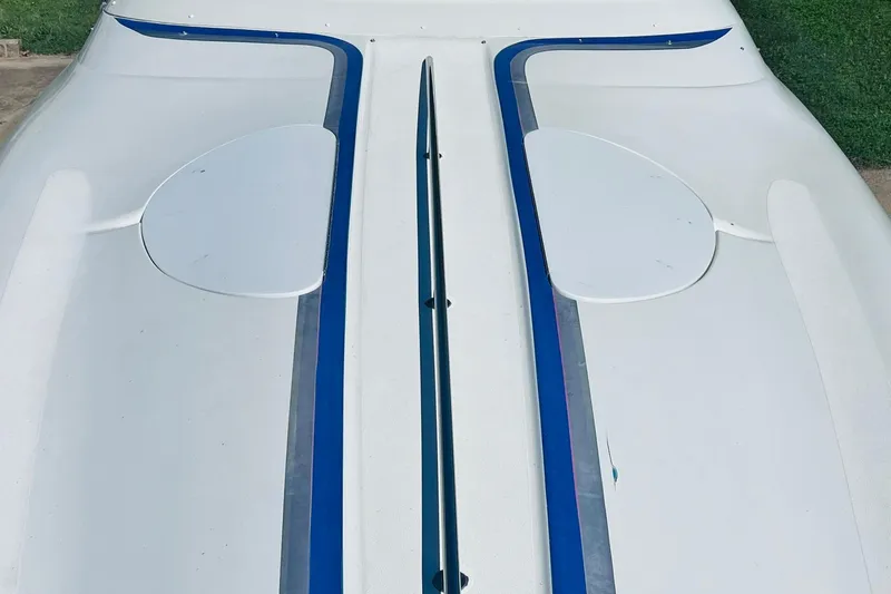 Slide: The Image of 1996 Baja .38 Special boat with sleek white and blue design on concrete surface. - 89