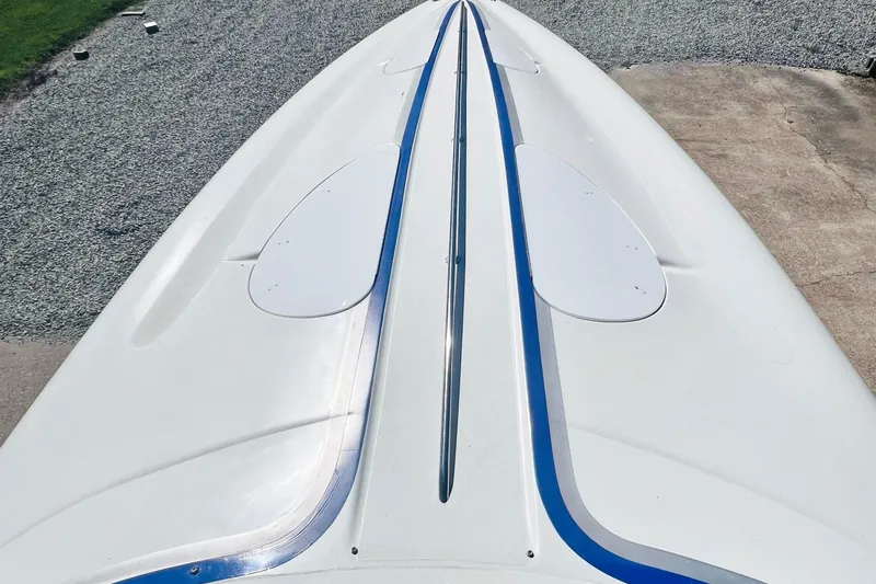 Slide: The Image of 1996 Baja .38 Special boat with sleek white and blue design, docked outdoors. - 90
