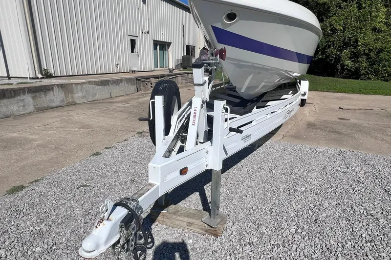 Slide: The Image of Top view of a 1996 Baja .38 Special boat with blue accents on gravel. - 94