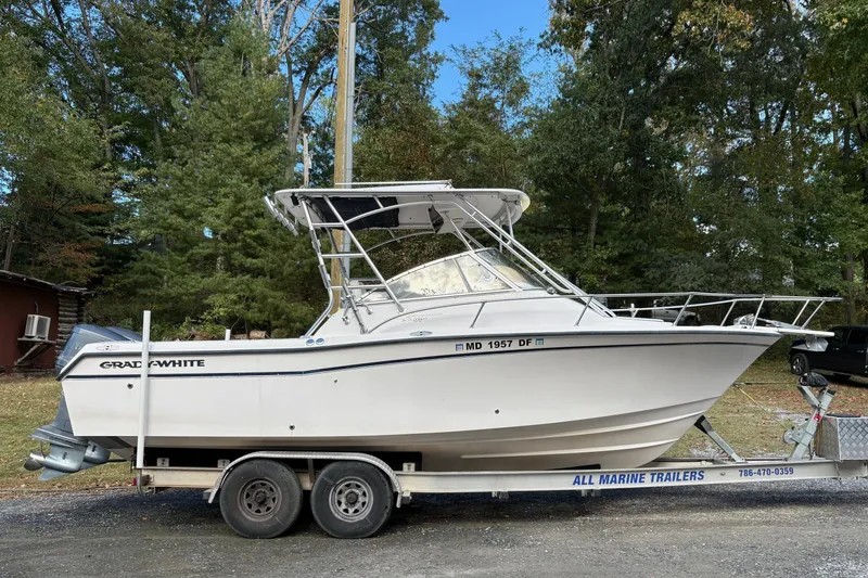 The Image of 2001 Grady-White Express 265 boat on trailer, surrounded by trees. - 0