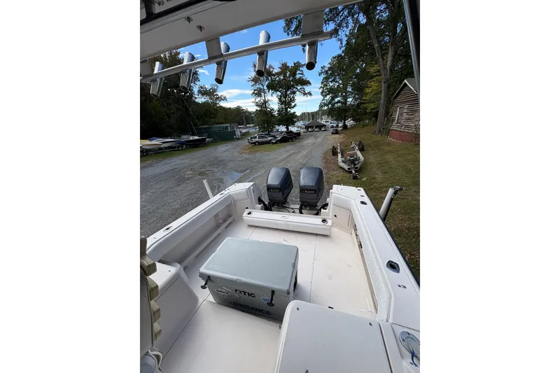 Slide: The Image of 2001 Grady-White Express 265 boat with twin engines, parked near a wooded area. - 21