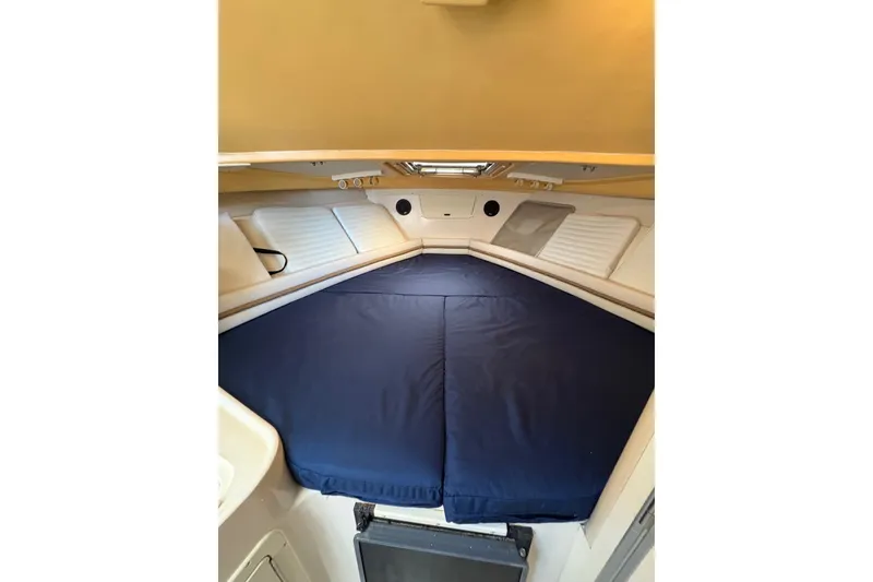 Slide: The Image of 2001 Grady-White Express 265 cabin interior with blue bedding and white walls. - 25