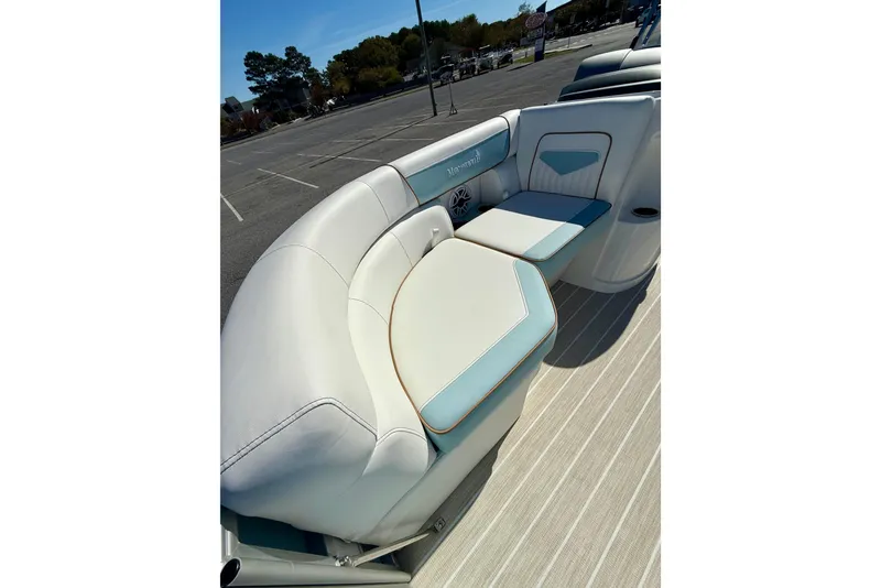 Slide: The Image of 2026 Berkshire 22RFX CHILL boat interior with white and blue seating in a parking lot. - 13