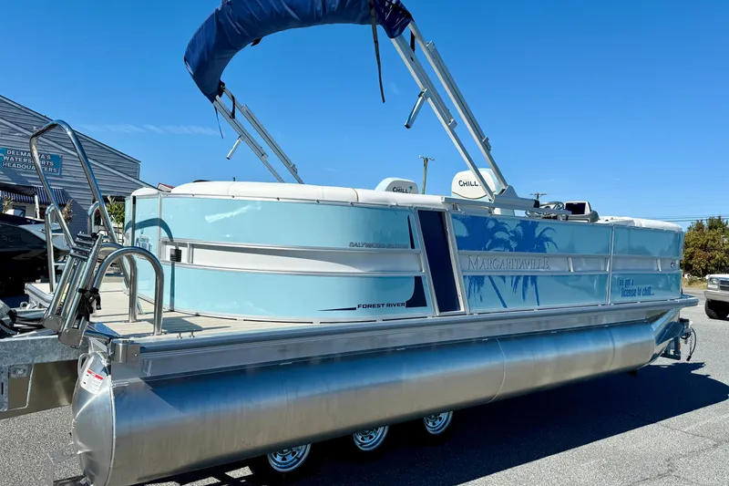 Slide: The Image of 2026 Berkshire 22RFX CHILL pontoon boat with blue canopy and Margaritaville branding. - 5