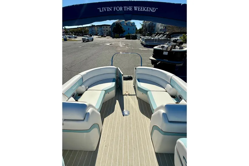 Slide: The Image of 2026 Berkshire 22RFX CHILL pontoon boat with spacious seating, docked under a "Livin' for the Weekend" canopy. - 7