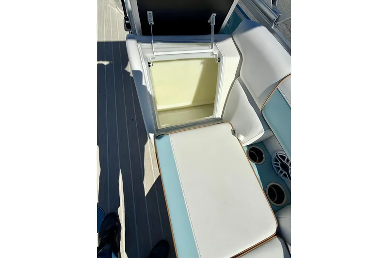 Slide: The Image of Open storage compartment on 2026 Berkshire 22RFX CHILL boat with cushioned seating. - 9