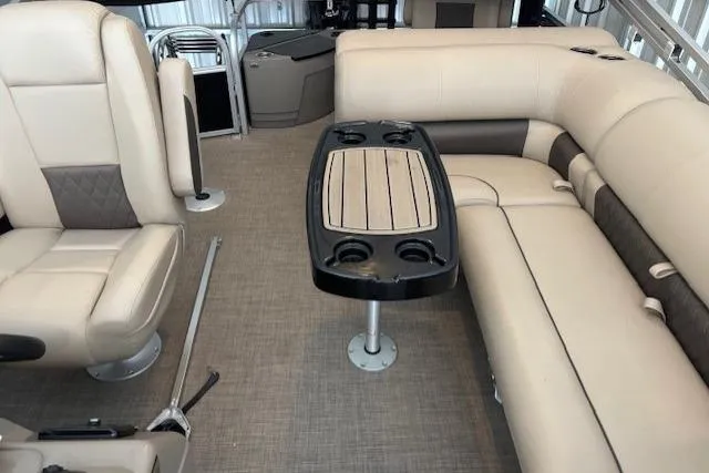 Slide: The Image of 2023 Sun Tracker SportFish 20 DLX interior with beige seating and central table. - 6