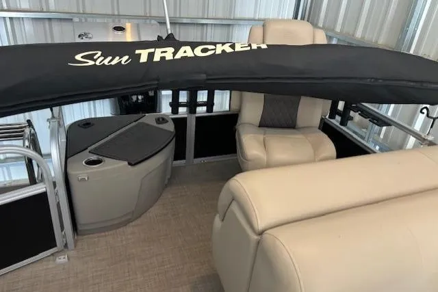 Slide: The Image of 2023 Sun Tracker SportFish 20 DLX interior with beige seating and branded cover. - 8