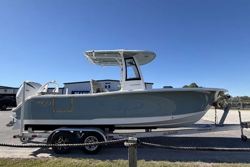 Slide: The Image of 2026 Sea Hunt Ultra 245 SE boat on trailer under clear blue sky. - 7