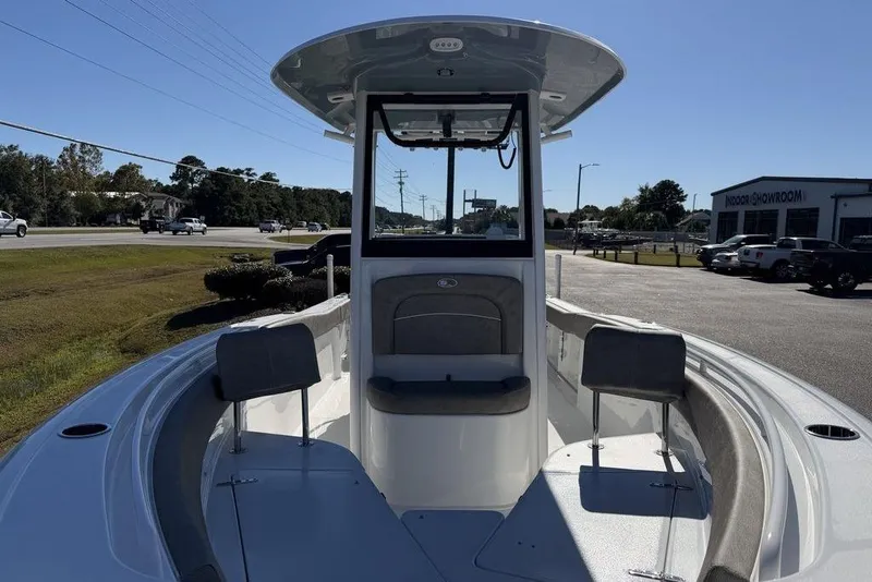 Slide: The Image of 2026 Sea Hunt Ultra 245 SE boat, front view, parked outdoors near showroom. - 9