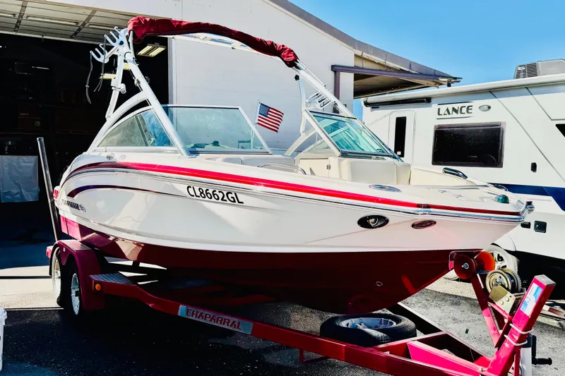 Slide: The Image of 2013 Chaparral 206 SSi boat on trailer, parked outdoors with American flag. - 1