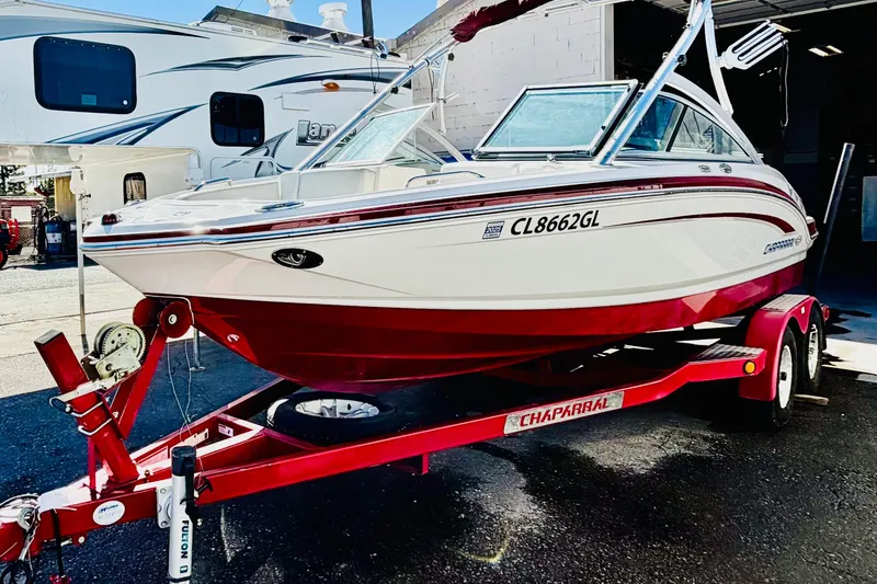 Slide: The Image of 2013 Chaparral 206 SSi boat on red trailer, parked outdoors. - 2