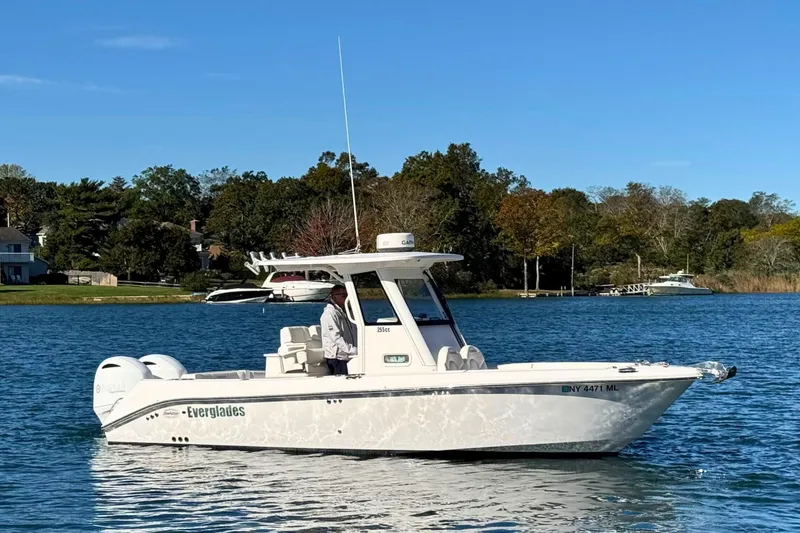 The Image of 2015 Everglades 255 Center Console boat on a serene lake with trees in the background. - 0