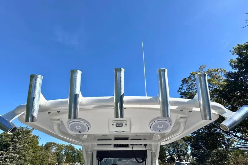 Slide: The Image of 2015 Everglades 255 Center Console boat with rod holders against clear blue sky. - 11