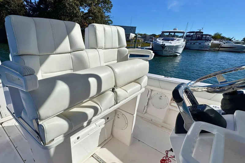 Slide: The Image of 2015 Everglades 255 Center Console boat interior with white seating and steering wheel. - 14