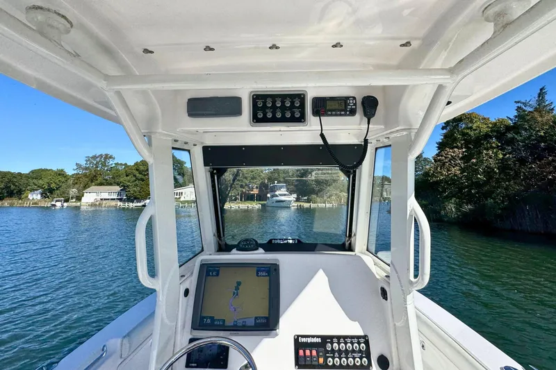 Slide: The Image of 2015 Everglades 255 Center Console boat navigating a scenic waterway with onboard electronics. - 16