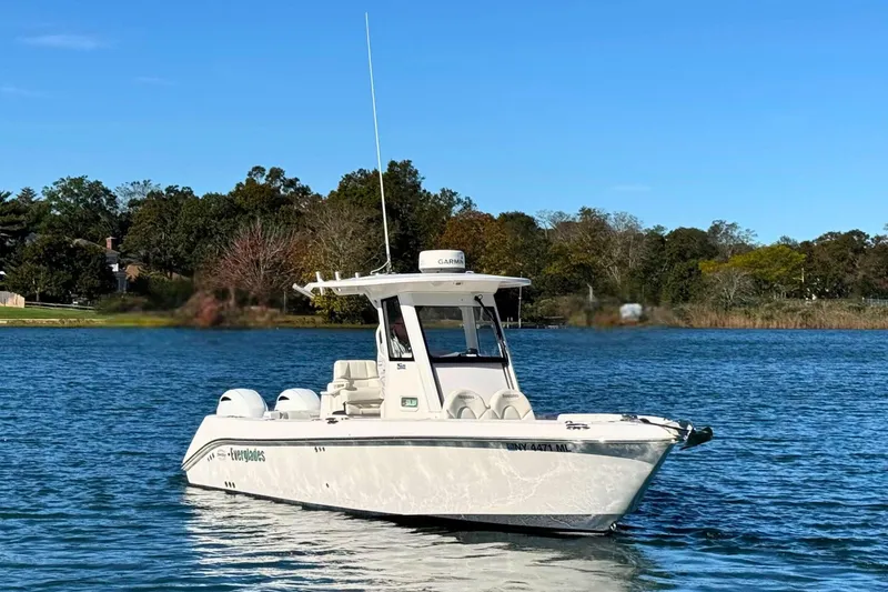 Slide: The Image of 2015 Everglades 255 Center Console boat on a serene lake with trees in the background. - 3