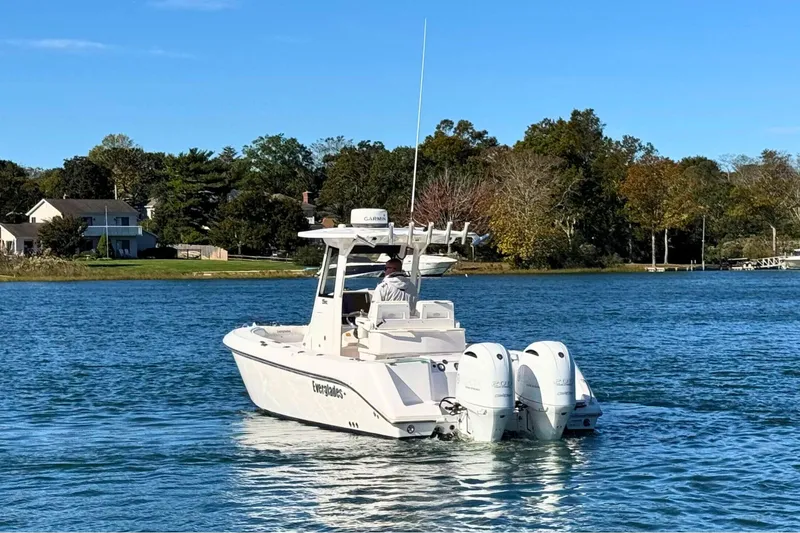 Slide: The Image of 2015 Everglades 255 Center Console boat on a serene lake with trees in the background. - 4