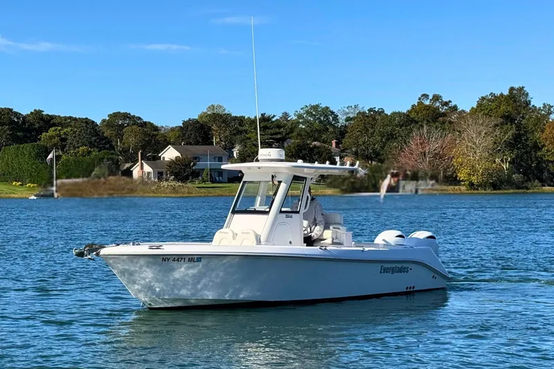 Slide: The Image of 2015 Everglades 255 Center Console boat on a serene lake with trees in the background. - 5