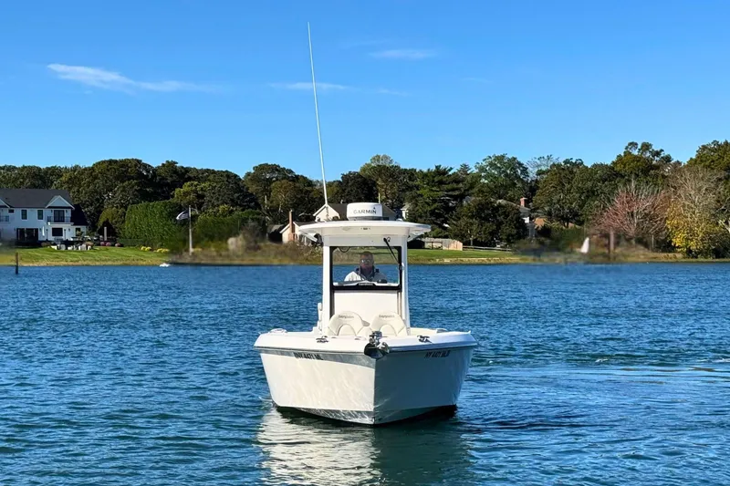 Slide: The Image of 2015 Everglades 255 Center Console boat on a serene lake with lush greenery. - 6