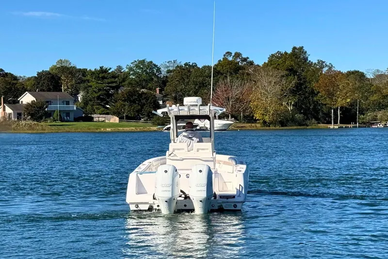 Slide: The Image of 2015 Everglades 255 Center Console boat cruising on a serene lake. - 7