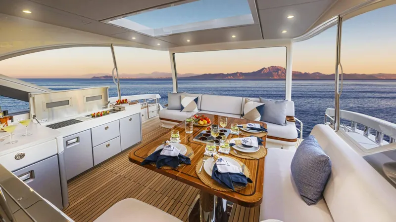 Slide: The Image of Luxurious 2025 Riviera 6800 Sport Yacht interior with elegant dining setup and ocean view. - 18