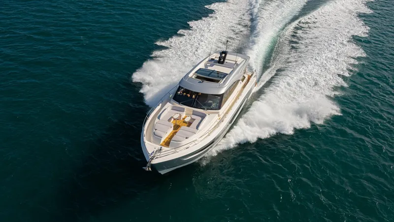 Slide: The Image of 2025 Riviera 6800 Sport Yacht Platinum Edition cruising on open water. - 2