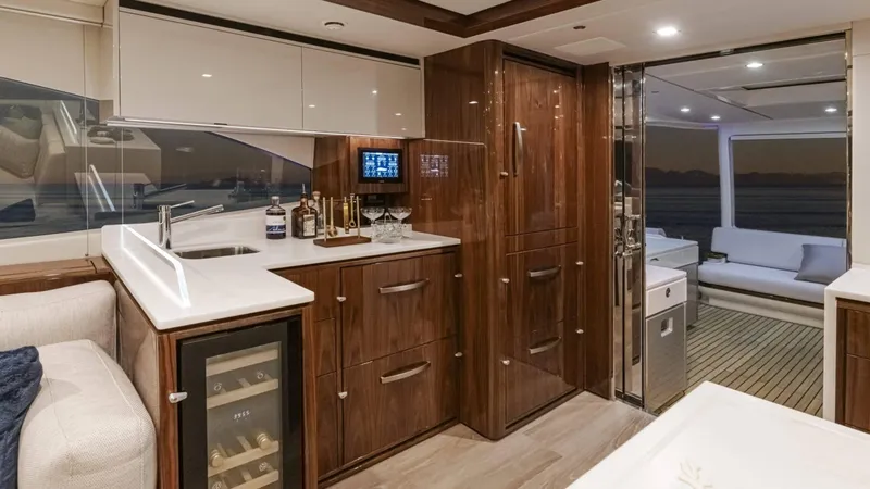 Slide: The Image of Luxurious interior of 2025 Riviera 6800 Sport Yacht Platinum Edition with modern kitchen and lounge area. - 20