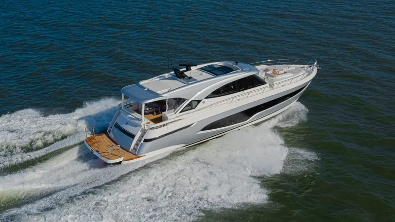Slide: The Image of 2025 Riviera 6800 Sport Yacht Platinum Edition cruising on open water. - 3