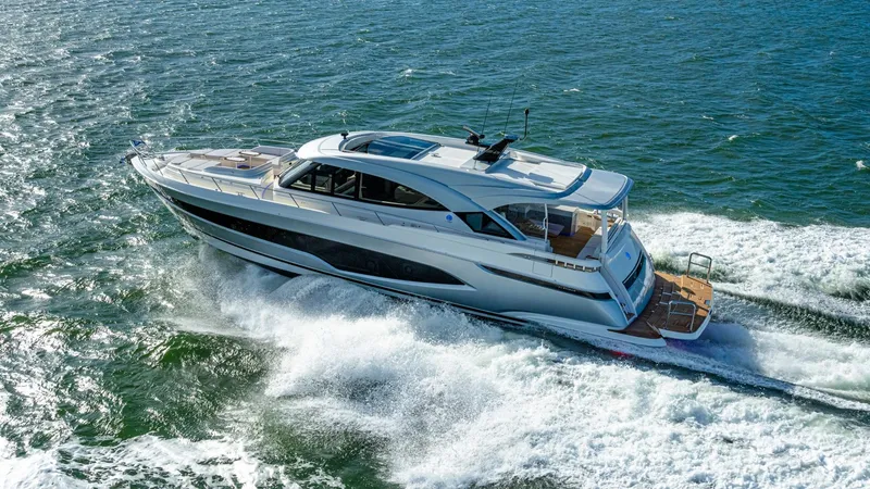Slide: The Image of 2025 Riviera 6800 Sport Yacht Platinum Edition cruising on open water. - 4