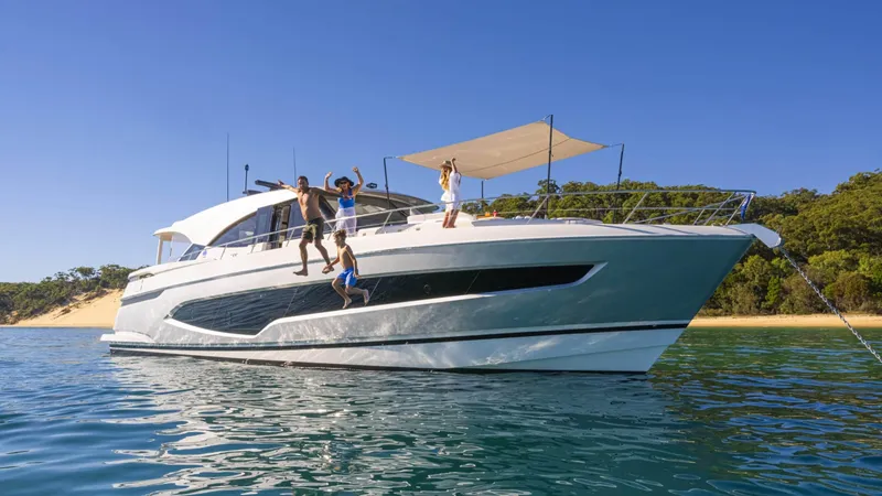 Slide: The Image of 2025 Riviera 6800 Sport Yacht Platinum Edition with people enjoying the water. - 6