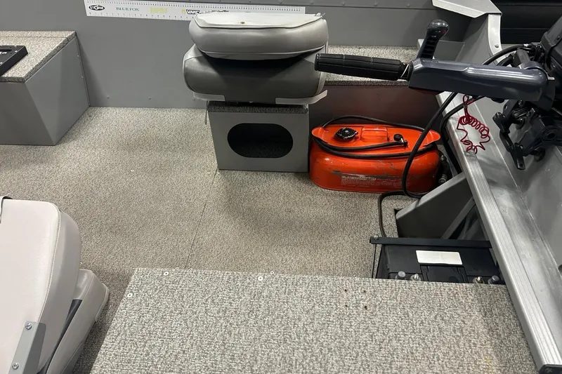 Slide: The Image of 2024 Alumacraft V16 boat interior with seating, motor controls, and fuel tank. - 9