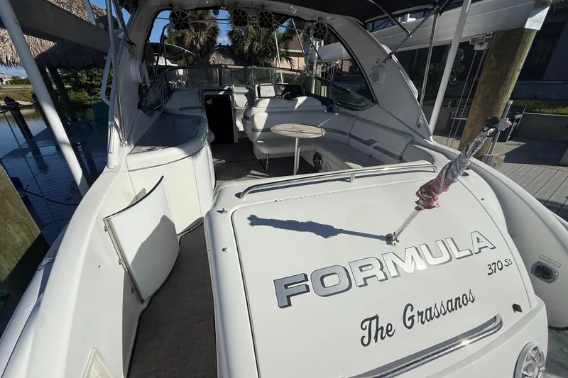 Slide: The Image of 2004 Formula 370 Super Sport boat interior with seating and table, docked at marina. - 11
