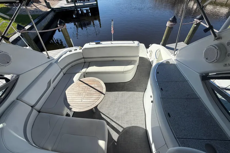 Slide: The Image of 2004 Formula 370 Super Sport boat interior with seating and table by the water. - 15