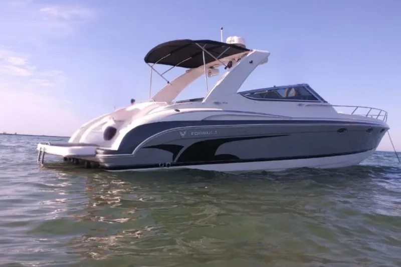 Slide: The Image of 2004 Formula 370 Super Sport boat on calm water under clear sky. - 2